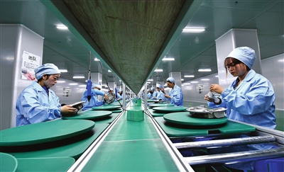 工人在银川闽商智能科技有限公司生产车间组装扫地机器人系列产品